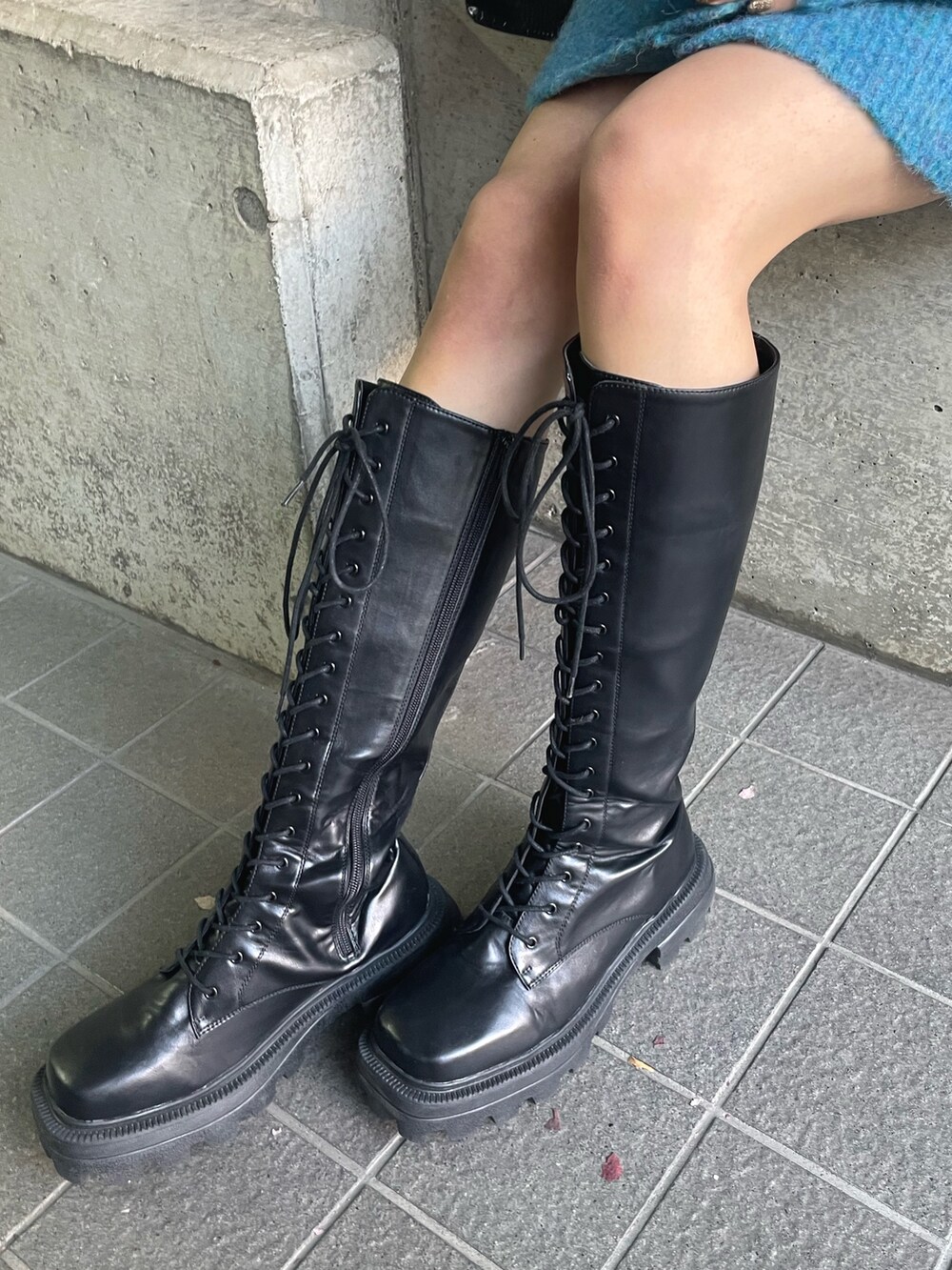 ブルー系のカーディガン/ボレロ、ブラック系のショルダーバッグ、ブラウン系のブーツを着用したレディースの秋コーディネートの7枚目の写真