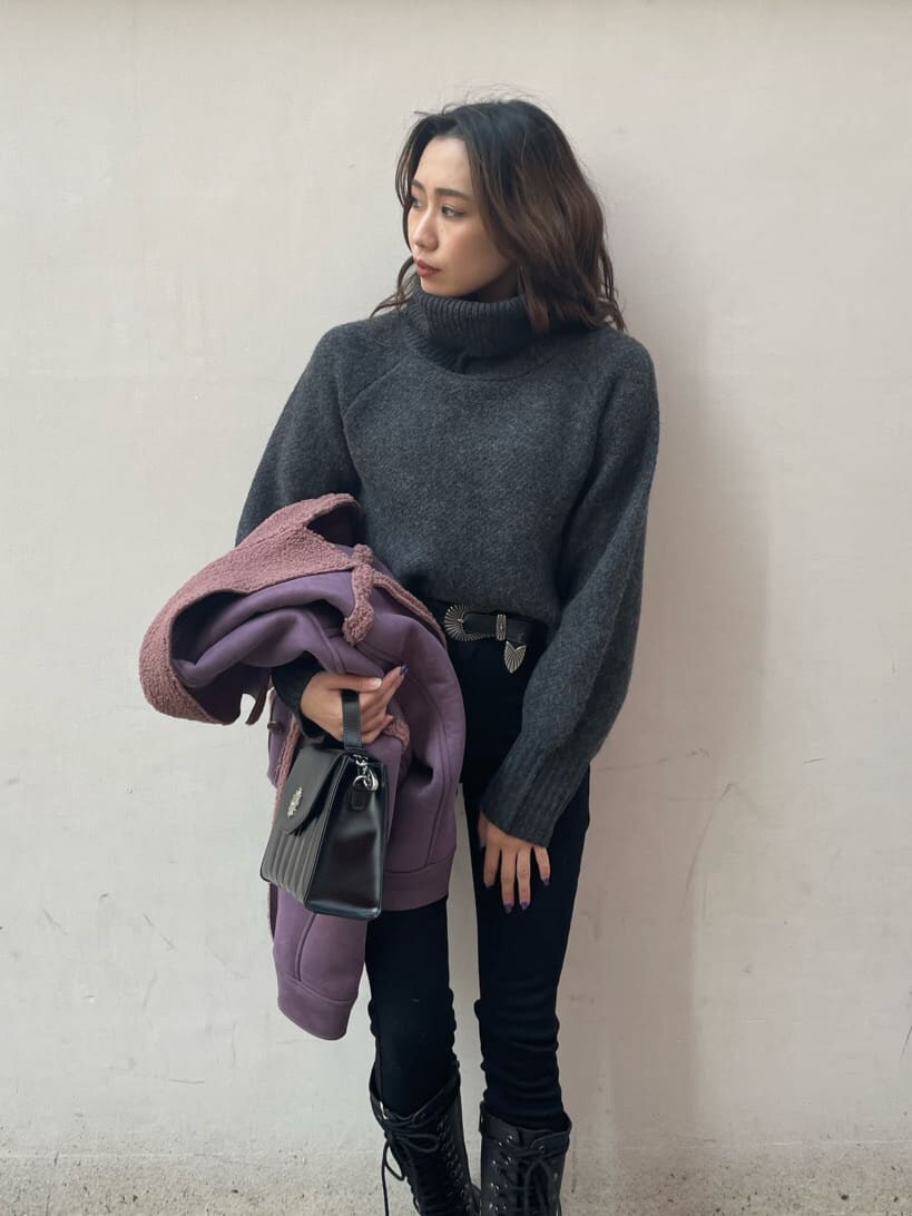 ブラック系のブーツ、パープル系のブルゾン、ブラック系のショルダーバッグを着用したレディースの冬コーディネートの4枚目の写真