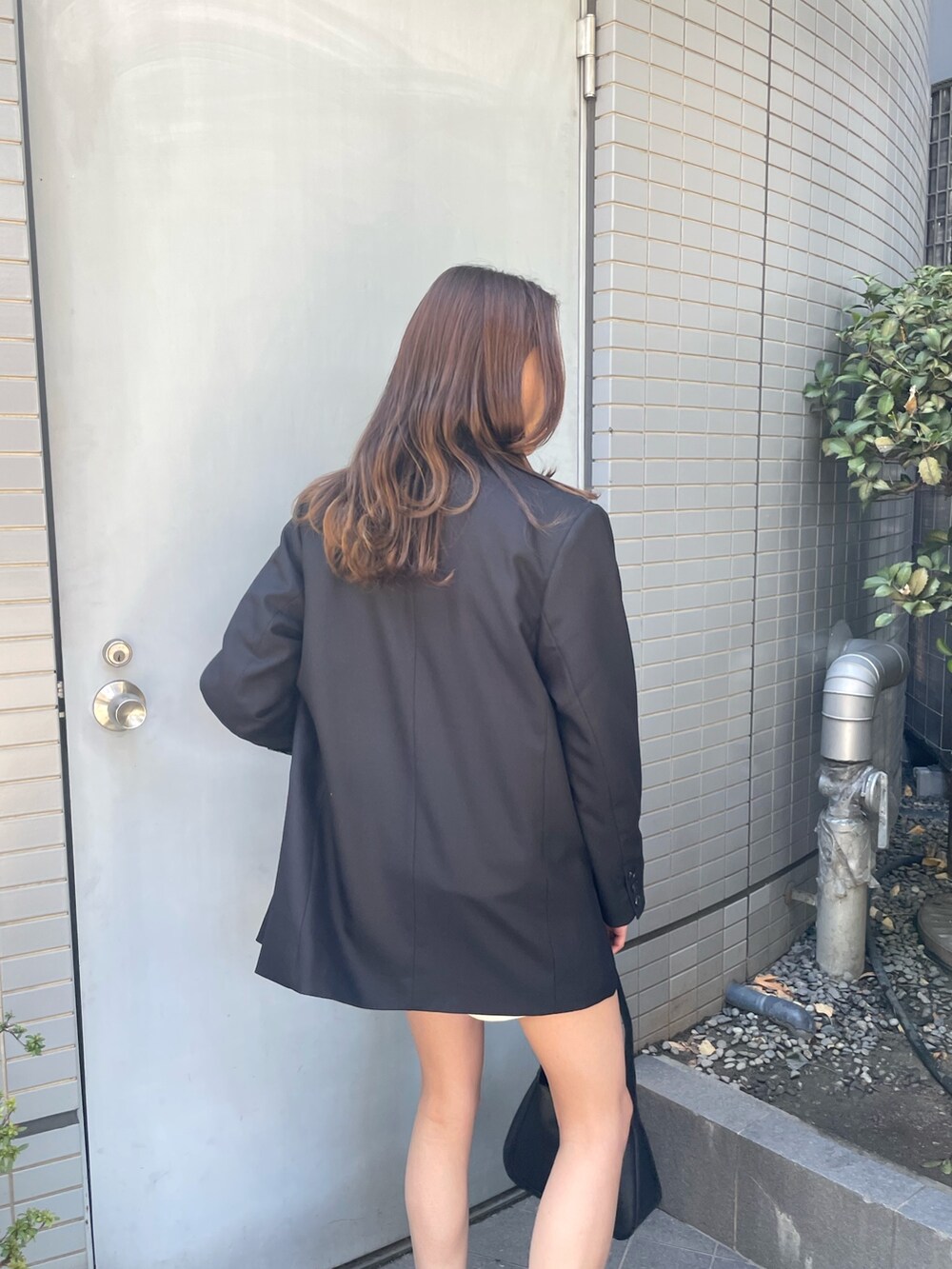 ブラック系のテーラードジャケット、グレー系のスウェット、ホワイト系のその他パンツを着用したレディースの冬コーディネートの4枚目の写真