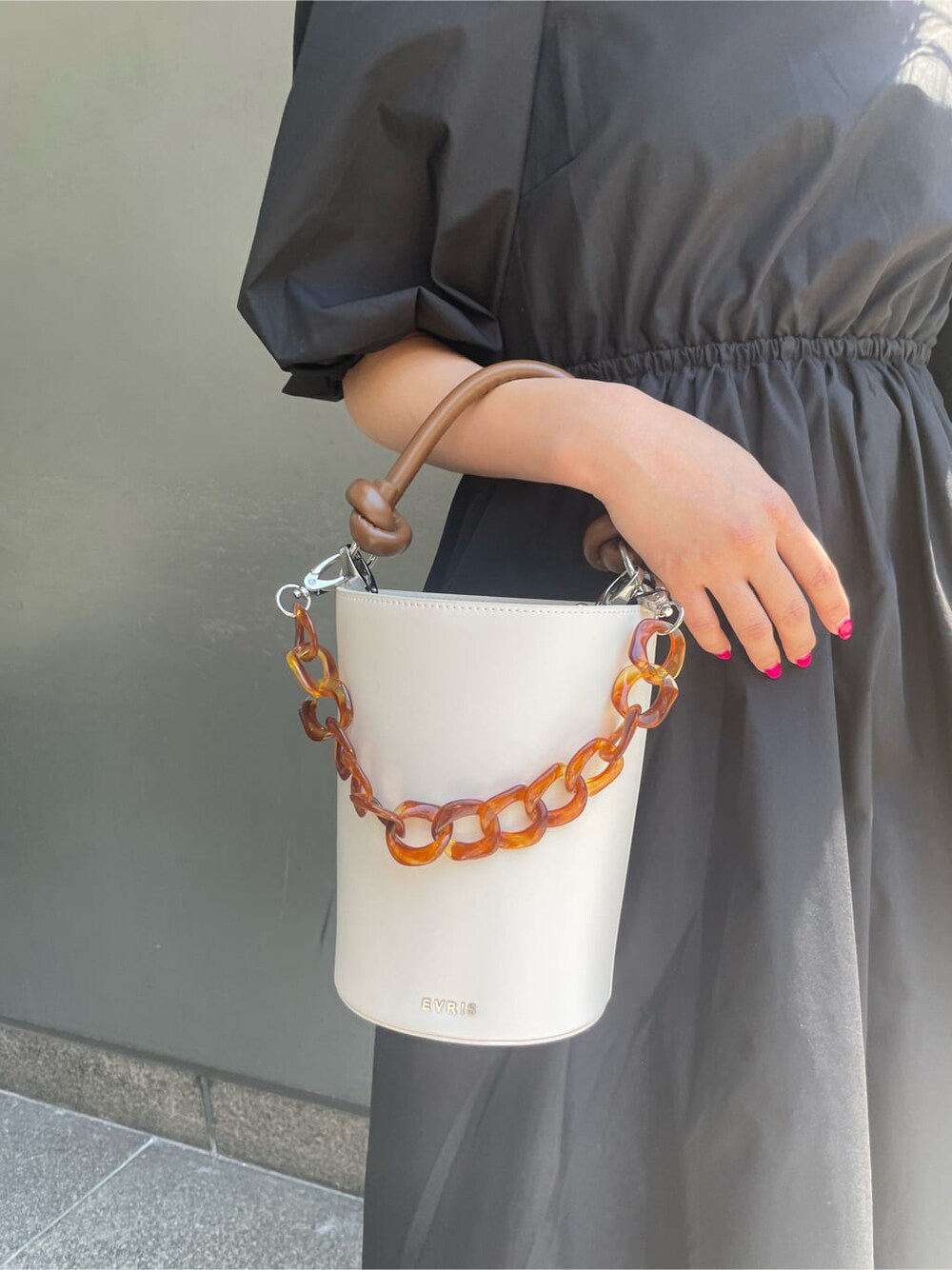 ブラック系のワンピース、ホワイト系のサンダル、ホワイト系のショルダーバッグを着用したレディースの春コーディネートの5枚目の写真