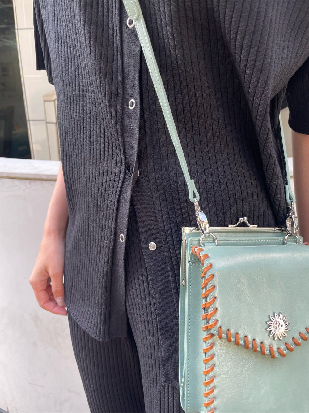 ブラック系のパンプス、グリーン系のショルダーバッグ、ブラック系のその他パンツを着用したレディースの春コーディネートの8枚目の写真