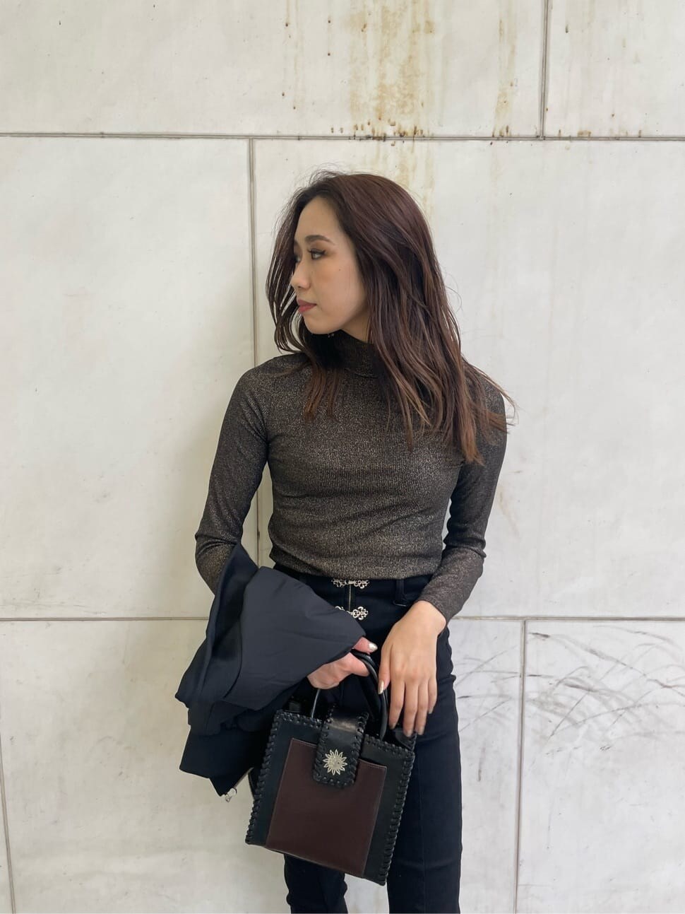 ブラック系のブーツ、ブラック系のデニムパンツ、ブラック系のショルダーバッグを着用したレディースの秋コーディネートの6枚目の写真