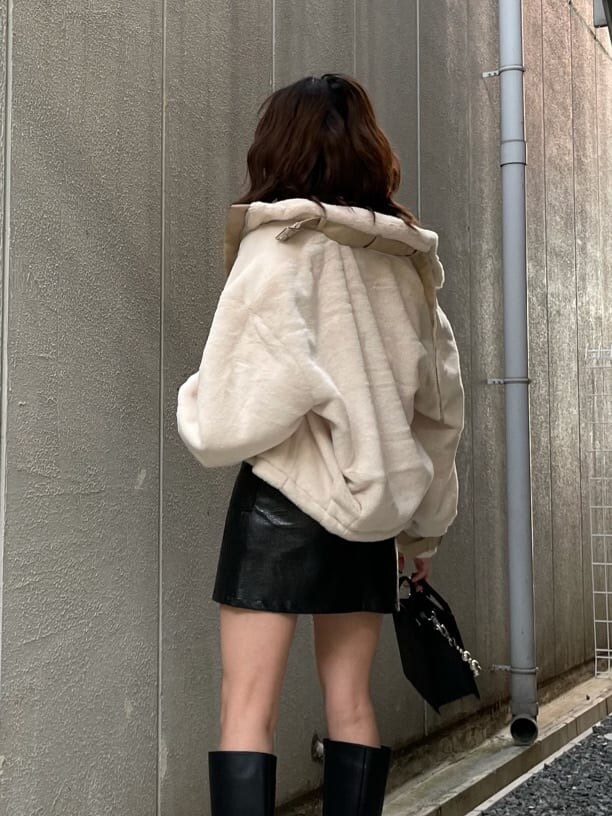 ブラック系のニット/セーター、ホワイト系のブルゾン、ブラック系のスカートを着用したレディースの秋コーディネートの5枚目の写真