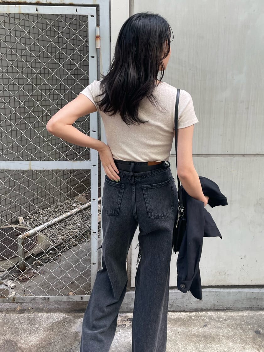 ブラック系のショルダーバッグ、ブラック系のデニムパンツ、ブラック系のブーツを着用したレディースの春コーディネートの9枚目の写真