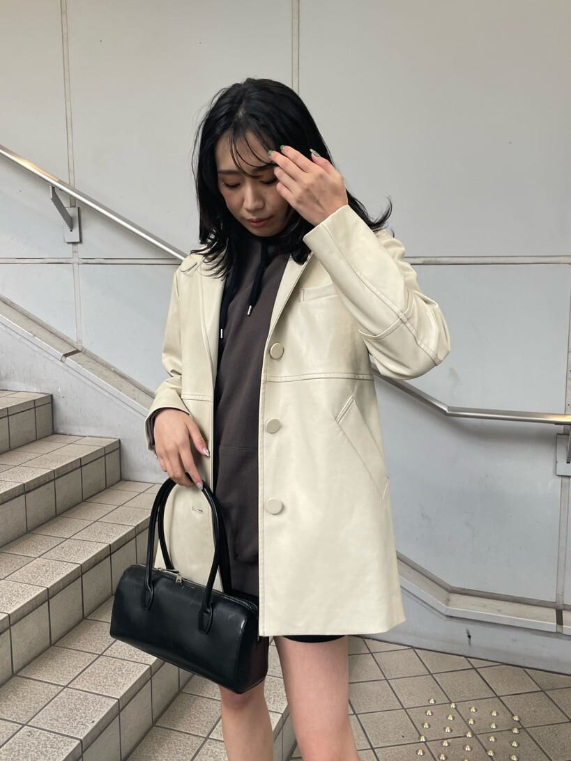 ホワイト系のテーラードジャケット、ブラック系のスカート、ブラック系のブーツを着用したレディースの冬コーディネートの3枚目の写真