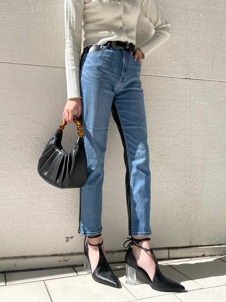 ブラック系のパンプス、ブルー系のデニムパンツ、ブラック系のハンドバッグを着用したレディースの春コーディネートの6枚目の写真