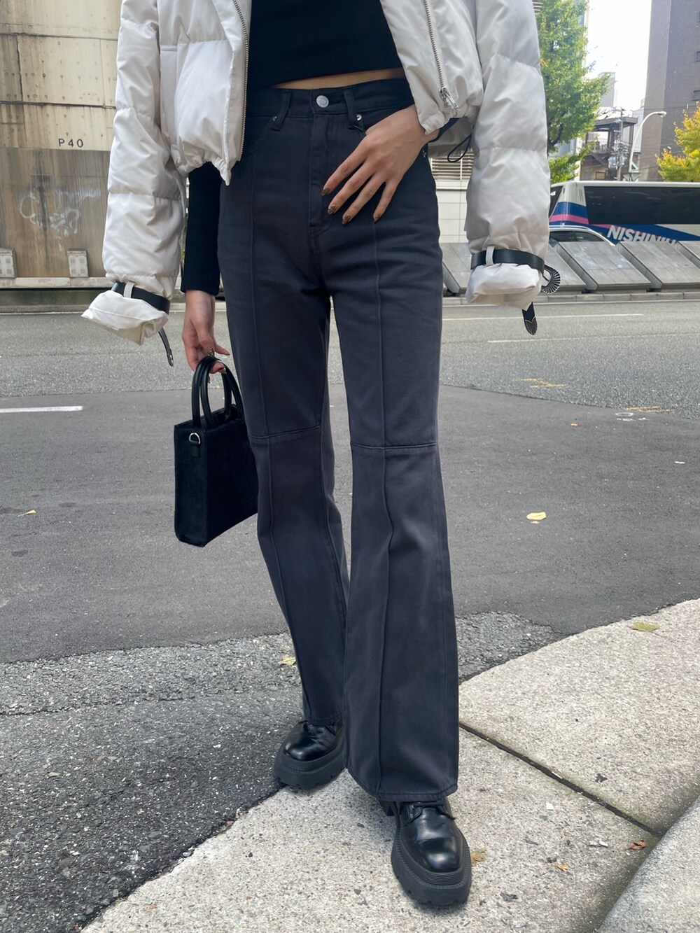 ホワイト系のダウンジャケット/コート、ブラック系のTシャツ/カットソー、ブラック系のショルダーバッグを着用したレディースの秋コーディネートの8枚目の写真