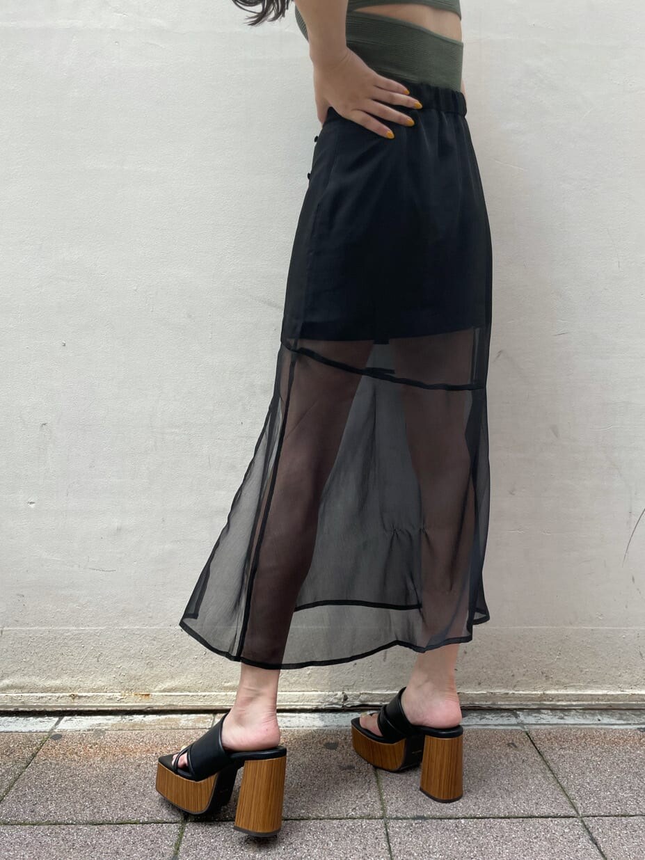 ブラック系のスカート、ブラック系のサンダル、ベージュ系のTシャツ/カットソーを着用したレディースの夏コーディネートの8枚目の写真