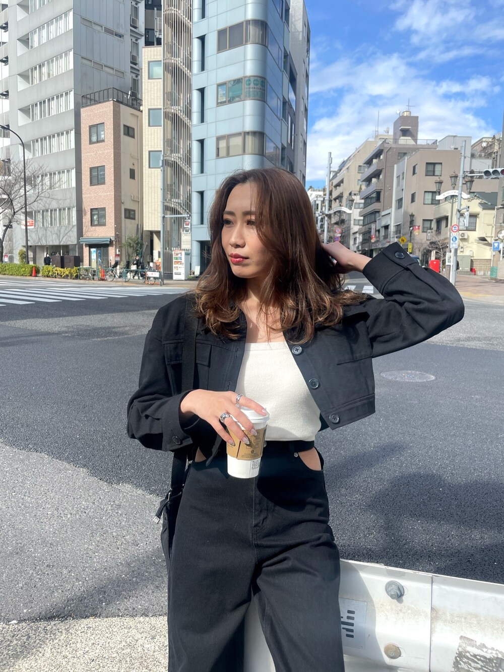 ブラック系のミリタリージャケット、ホワイト系のニット/セーター、ブラック系のデニムパンツを着用したレディースの春コーディネートの3枚目の写真