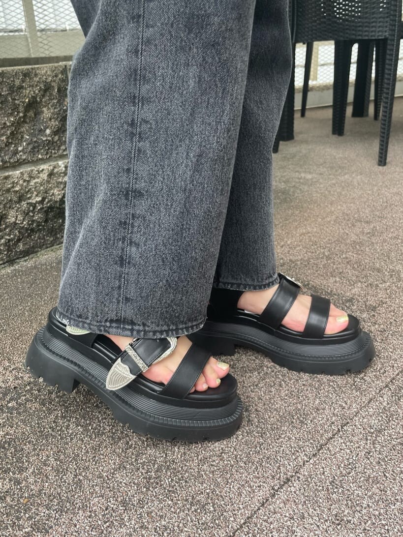 ブラック系のデニムパンツ、ブラック系のキャミソール、ホワイト系のカーディガン/ボレロを着用したレディースの春コーディネートの7枚目の写真