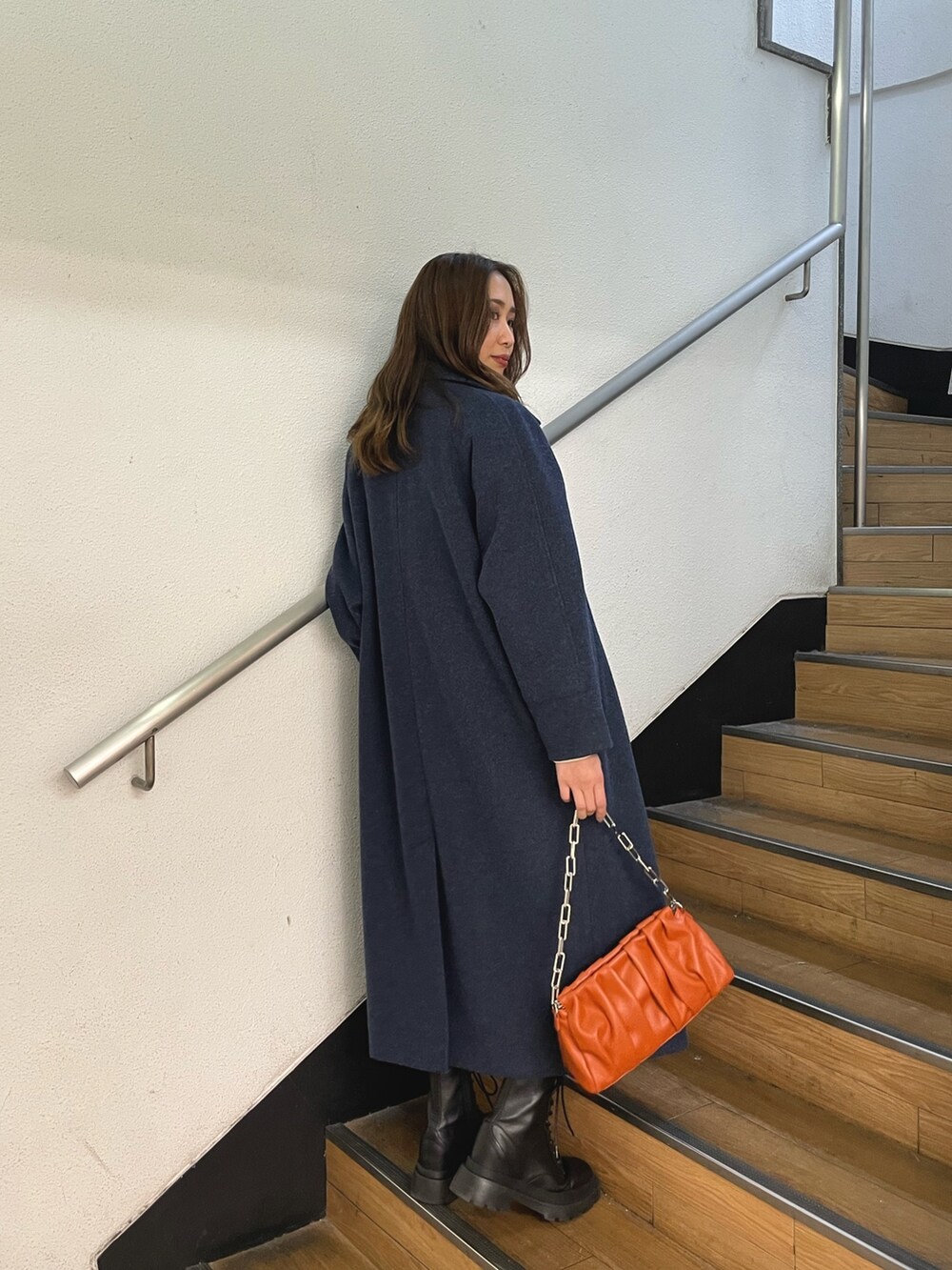 ブラック系のブーツ、ホワイト系のスウェット、ブルー系のその他アウターを着用したレディースの冬コーディネートの7枚目の写真