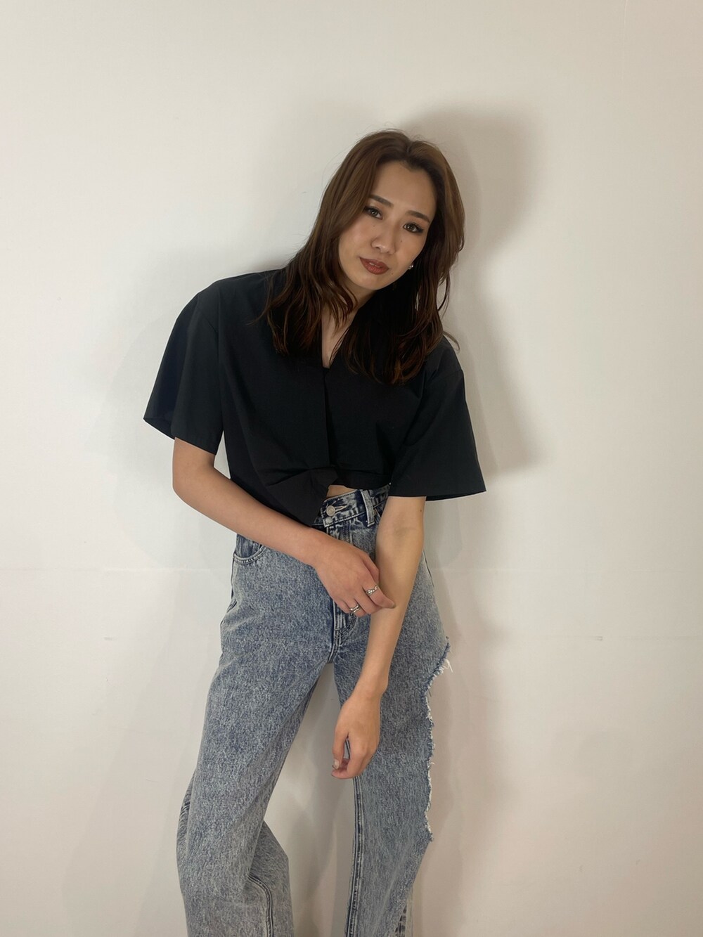 ブルー系のデニムパンツ、ブラック系のシャツ/ブラウス、ブラック系のスニーカーを着用したレディースの夏コーディネートの3枚目の写真