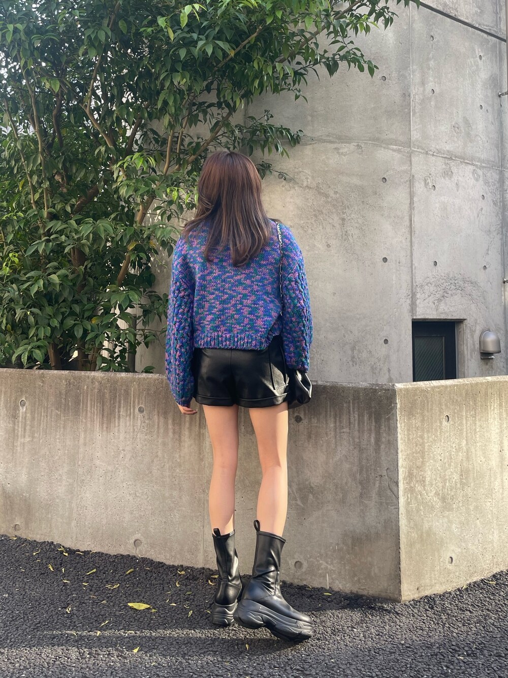 ブルー系のニット/セーター、ブラック系のブーツ、ブラック系のショルダーバッグを着用したレディースの秋コーディネートの6枚目の写真