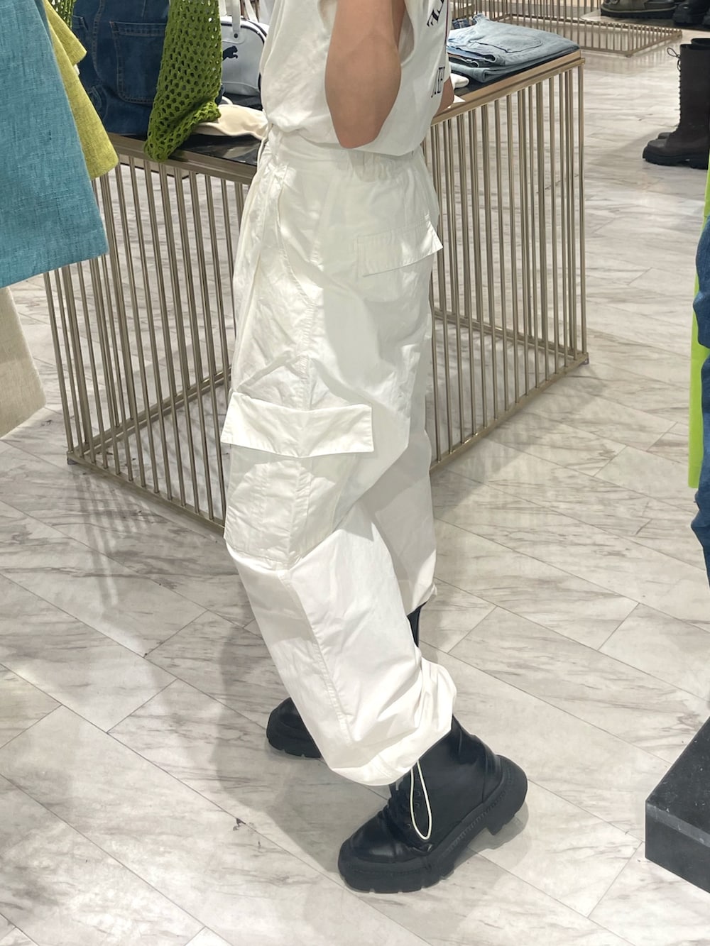 ホワイト系のカーゴパンツ、ホワイト系のTシャツ/カットソー、ブラック系のブーツを着用したレディースの春コーディネートの5枚目の写真