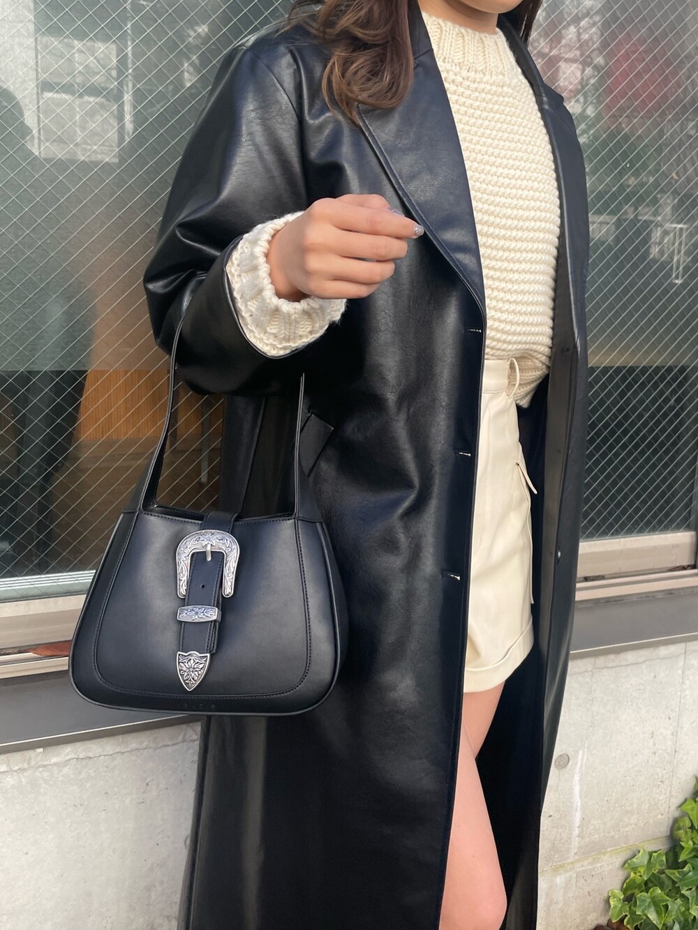 ホワイト系のニット/セーター、ホワイト系のその他パンツ、ブラック系のハンドバッグを着用したレディースの冬コーディネートの5枚目の写真