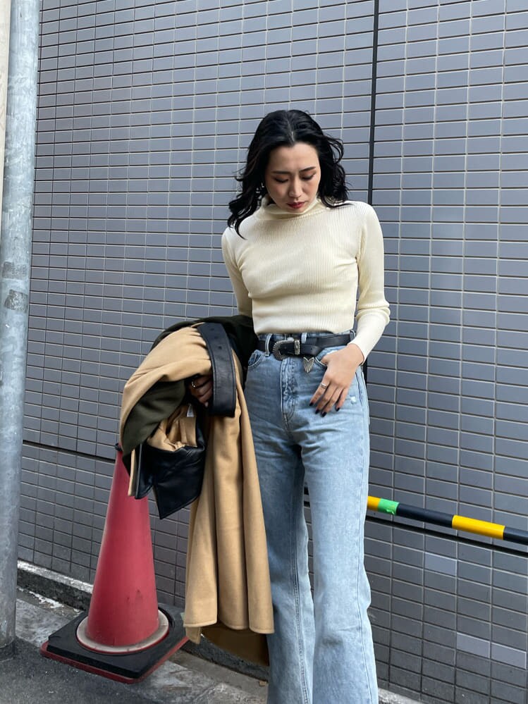 ブルー系のデニムパンツ、ブラック系のブーツ、ホワイト系のニット/セーターを着用したレディースの冬コーディネートの5枚目の写真