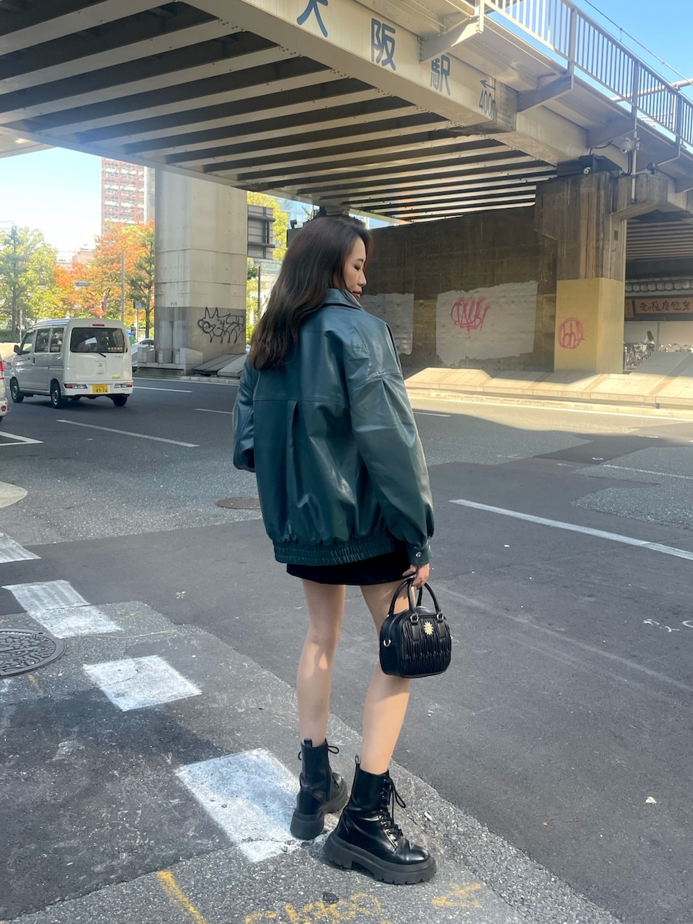 ホワイト系のショルダーバッグ、ブラック系のスカート、ブラック系のTシャツ/カットソーを着用したレディースの秋コーディネートの2枚目の写真