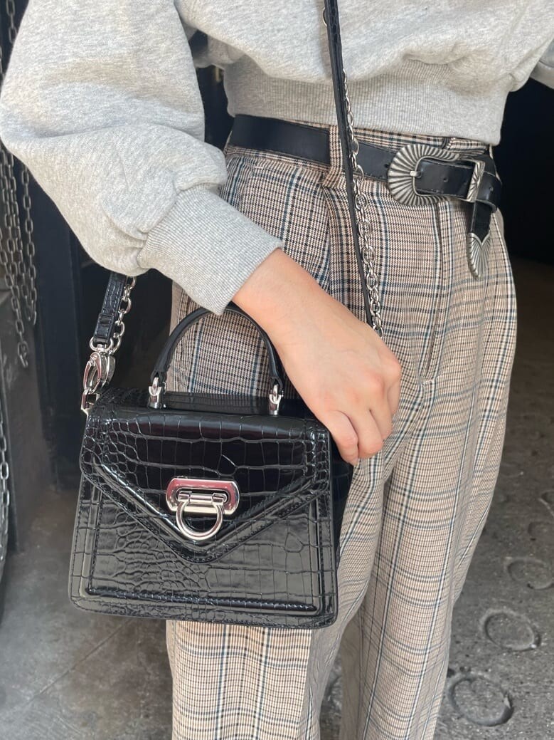 ブラック系のブーツ、その他のその他パンツ、ブラック系のハンドバッグを着用したレディースの秋コーディネートの5枚目の写真