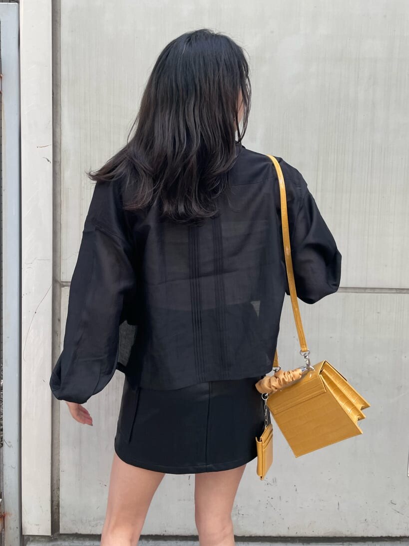 ホワイト系のキャミソール、ブラック系のブーツ、ブラック系のスカートを着用したレディースの春コーディネートの4枚目の写真