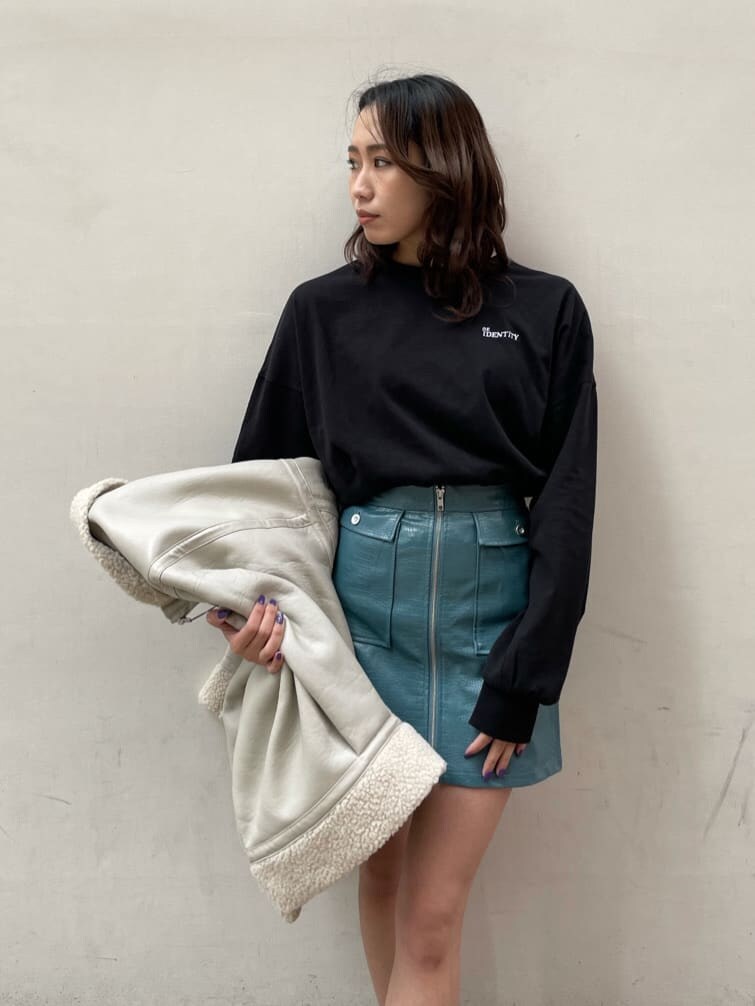 ホワイト系のブルゾン、ブルー系のスカート、ブラック系のTシャツ/カットソーを着用したレディースの冬コーディネートの5枚目の写真