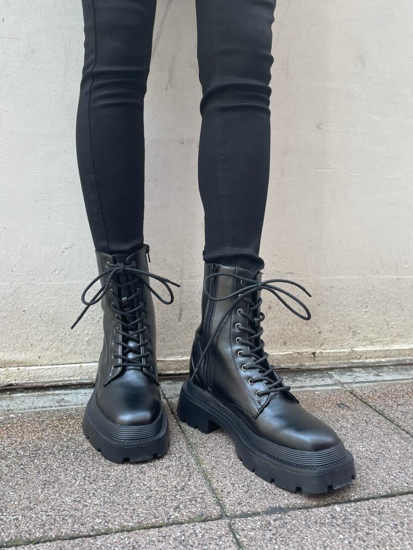 ブラック系のニット/セーター、ブラック系のブーツ、ブラック系のデニムパンツを着用したレディースの夏コーディネートの6枚目の写真