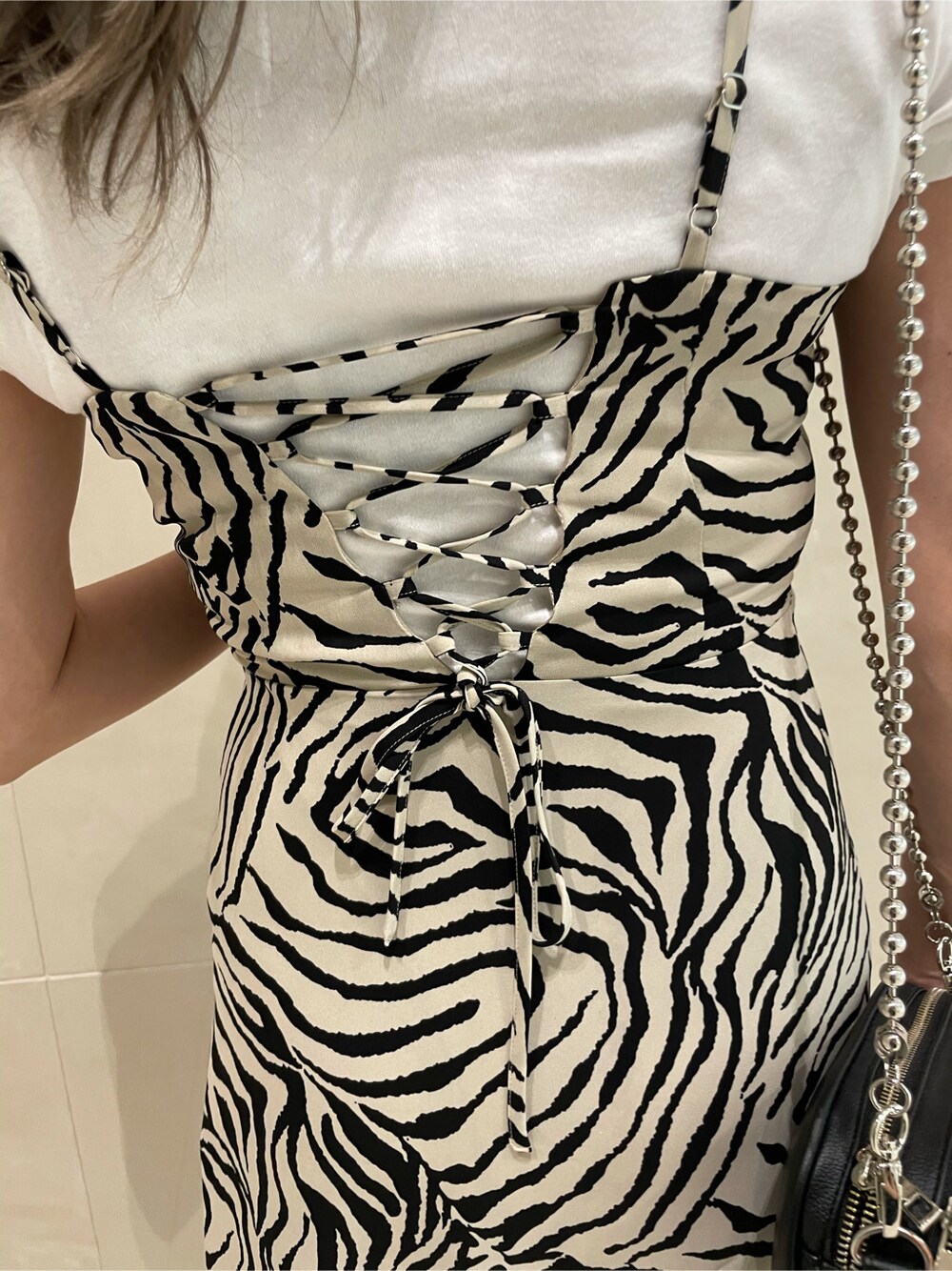 ホワイト系のTシャツ/カットソー、ホワイト系のサンダル、シルバー系のネックレスを着用したレディースの春コーディネートの5枚目の写真