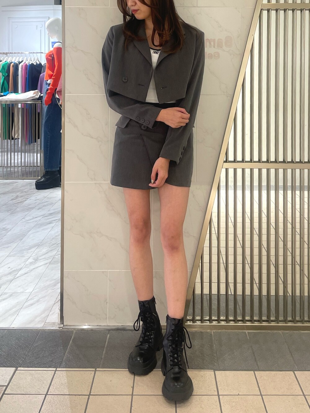 グレー系のテーラードジャケット、グレー系のスカート、ホワイト系のTシャツ/カットソーを着用したレディースの春コーディネートの2枚目の写真