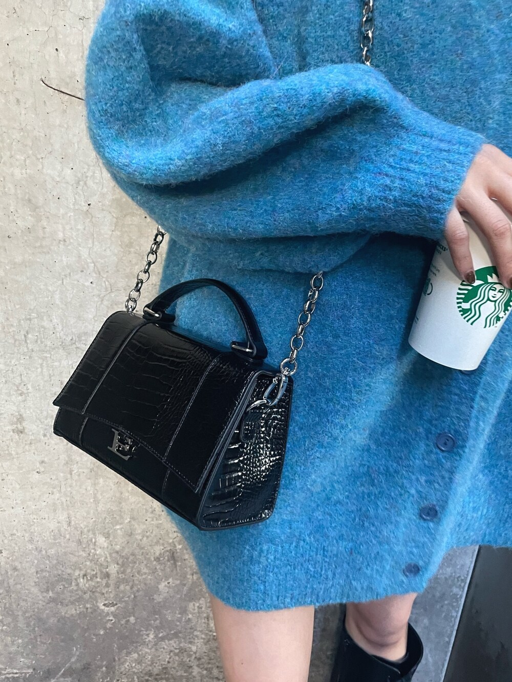 ブルー系のカーディガン/ボレロ、ブラック系のショルダーバッグ、ブラウン系のブーツを着用したレディースの秋コーディネートの4枚目の写真