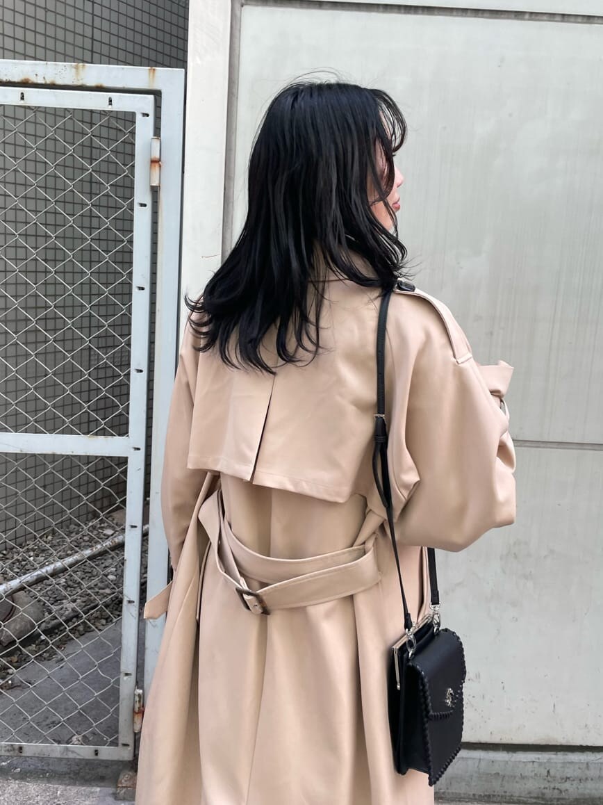 ベージュ系のスカート、ブラック系のブーツ、ベージュ系のトレンチコートを着用したレディースの春コーディネートの4枚目の写真