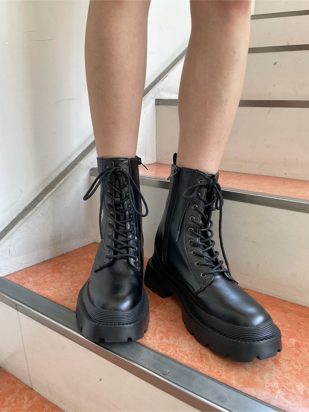 ブラック系のワンピース、ブラック系のブーツ、ベージュ系のショルダーバッグを着用したレディースの秋コーディネートの5枚目の写真