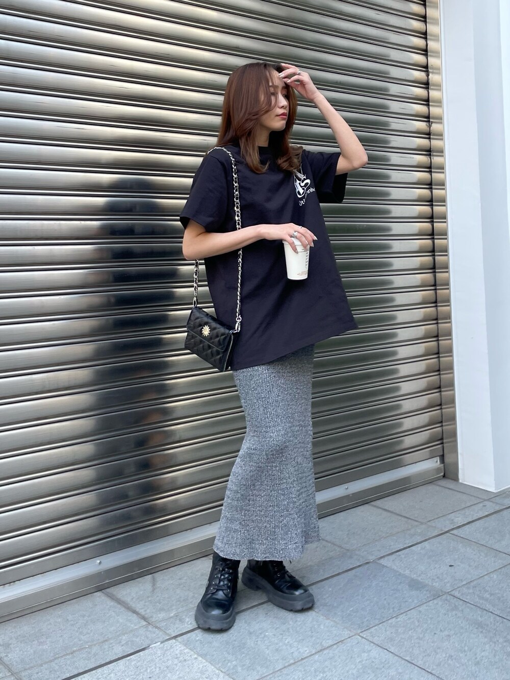 ブラック系のTシャツ/カットソー、ブラック系のショルダーバッグ、ブラック系のブーツを着用したレディースの春コーディネートの5枚目の写真