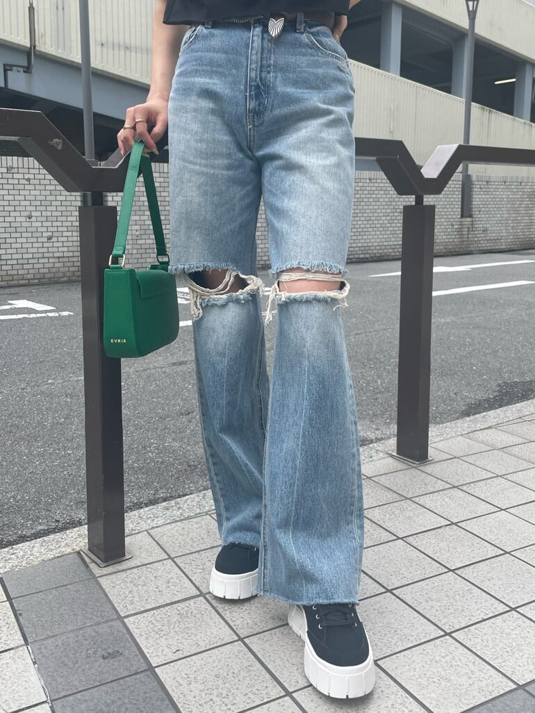 グリーン系のショルダーバッグ、ブルー系のデニムパンツ、ブラック系のスニーカーを着用したレディースの夏コーディネートの7枚目の写真