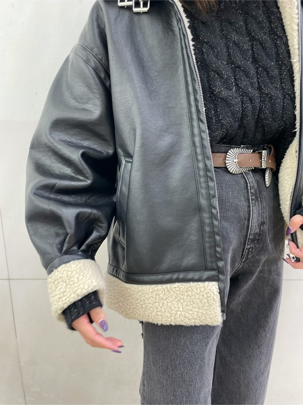 ブラック系のデニムパンツ、ブラック系のブルゾン、ブラック系のニット/セーターを着用したレディースの秋コーディネートの7枚目の写真