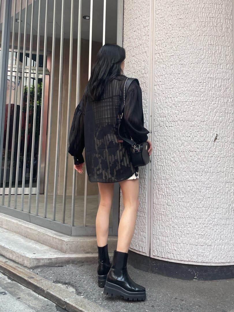 ブラック系のブーツ、ブラック系のシャツ/ブラウス、ブラック系のショルダーバッグを着用したレディースの夏コーディネートの2枚目の写真