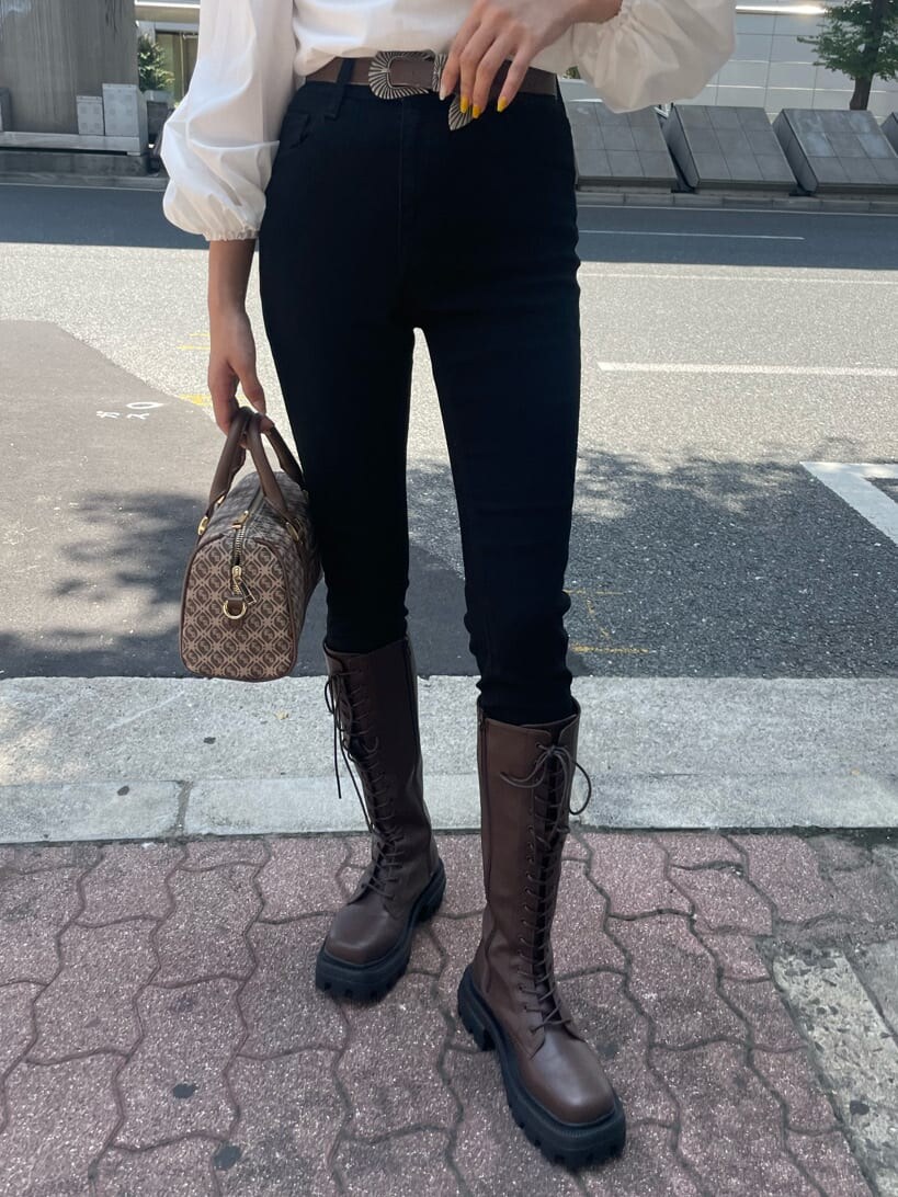 ブラウン系のブーツ、ブラウン系のボストンバッグ、ホワイト系のシャツ/ブラウスを着用したレディースの秋コーディネートの8枚目の写真