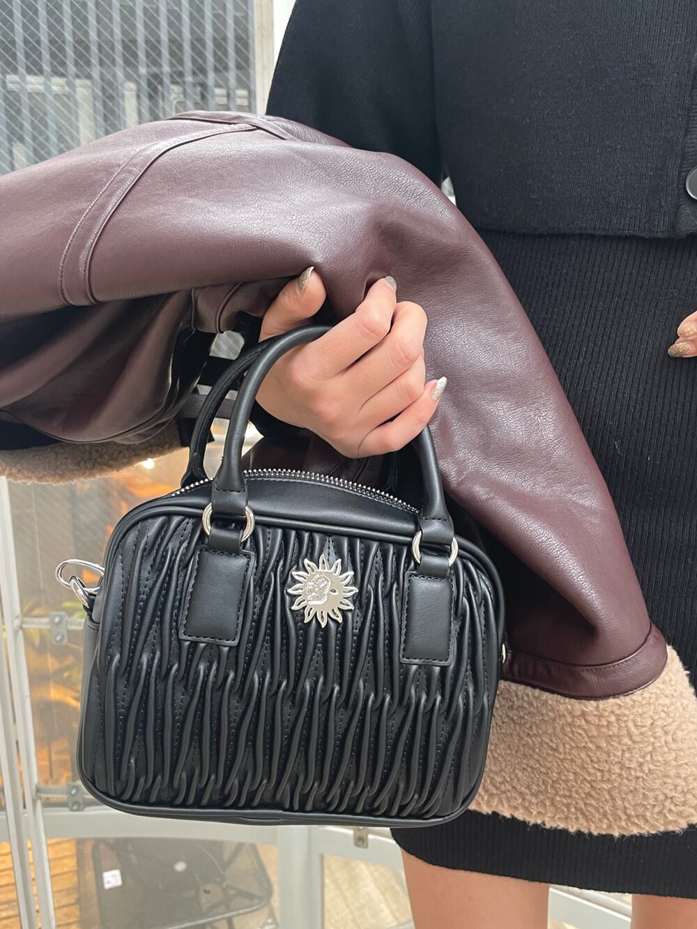 ブラック系のブーツ、ブラック系のショルダーバッグ、ブラウン系のブルゾンを着用したレディースの冬コーディネートの7枚目の写真