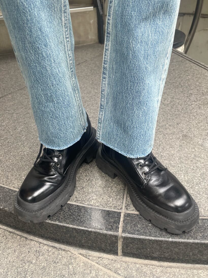 ブラック系のブーツ、ブラック系のテーラードジャケット、ブラック系のハンドバッグを着用したレディースの秋コーディネートの10枚目の写真