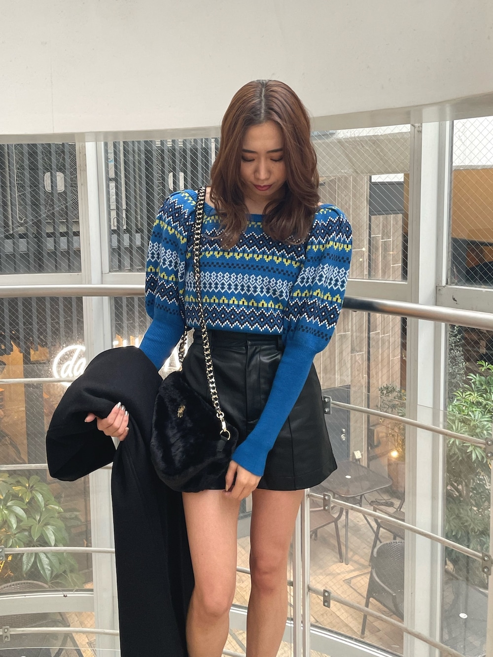 ブラック系のブーツ、ブラック系のその他パンツ、ブラック系のショルダーバッグを着用したレディースの冬コーディネートの4枚目の写真