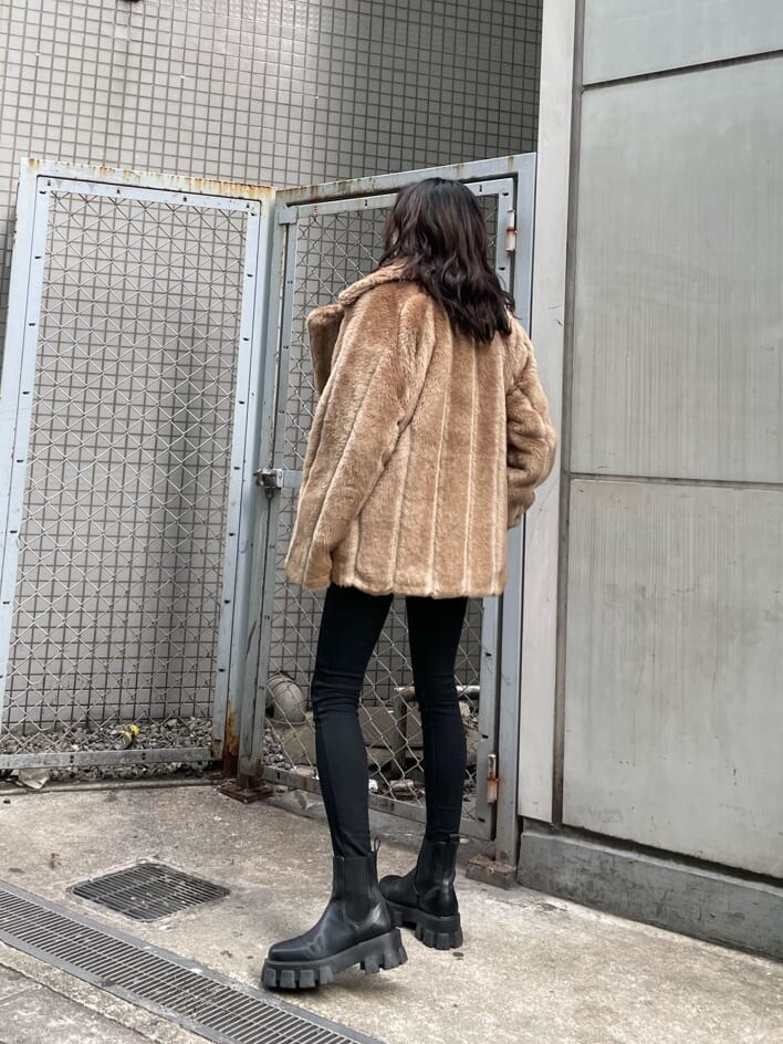 ブラック系のデニムパンツ、ベージュ系のその他アウター、ブラック系のブーツを着用したレディースの冬コーディネートの5枚目の写真