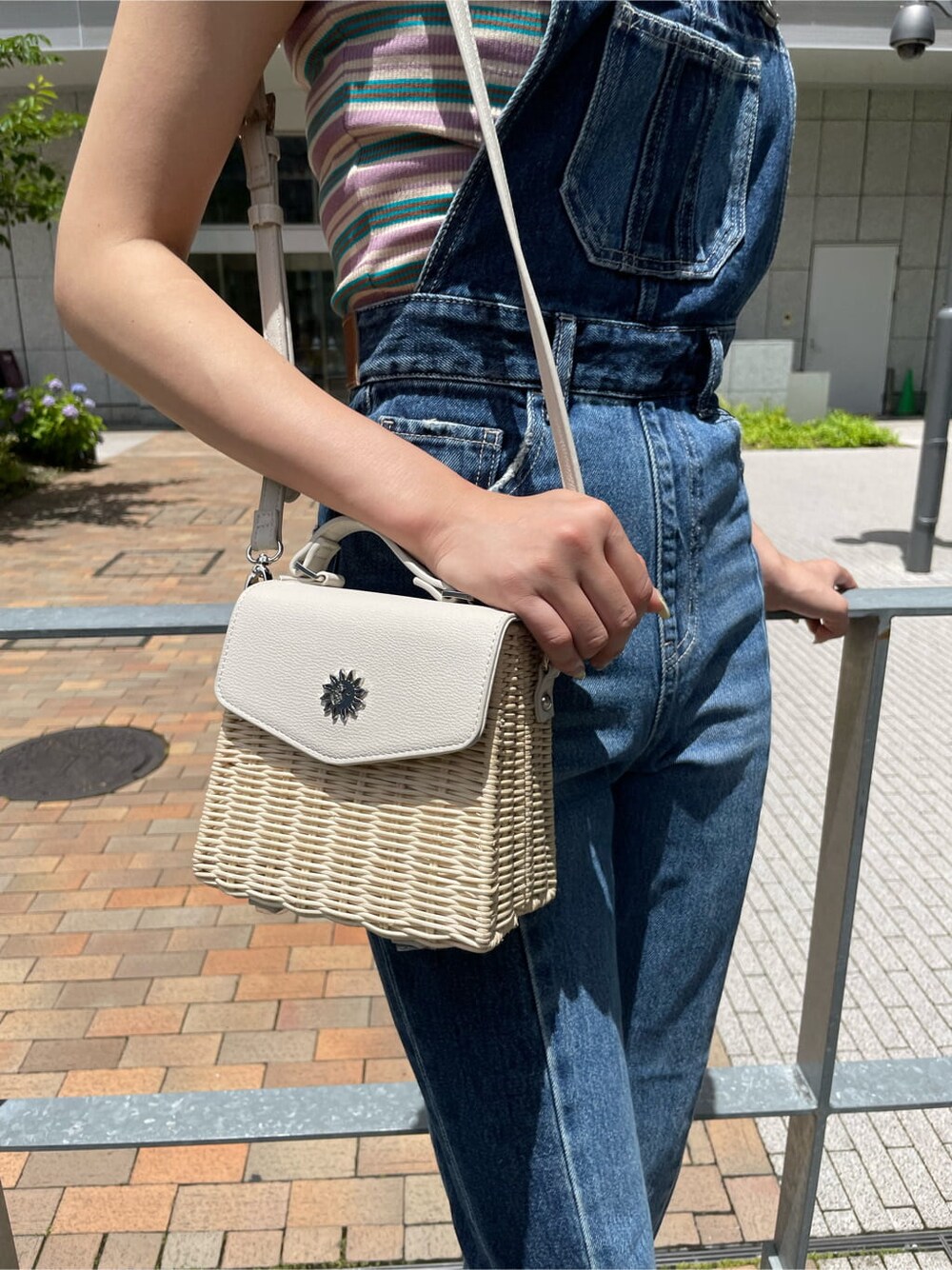 ブルー系のサロペット/オーバーオール、ホワイト系のサンダル、グリーン系のTシャツ/カットソーを着用したレディースの夏コーディネートの5枚目の写真