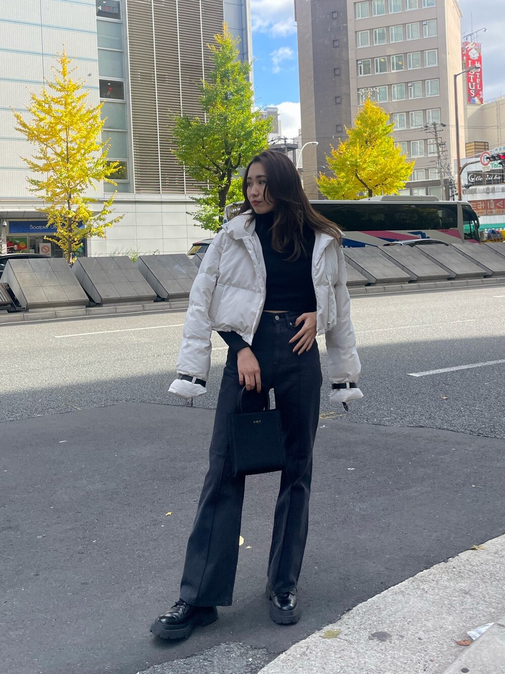 ホワイト系のダウンジャケット/コート、ブラック系のTシャツ/カットソー、ブラック系のショルダーバッグを着用したレディースの秋コーディネートの2枚目の写真