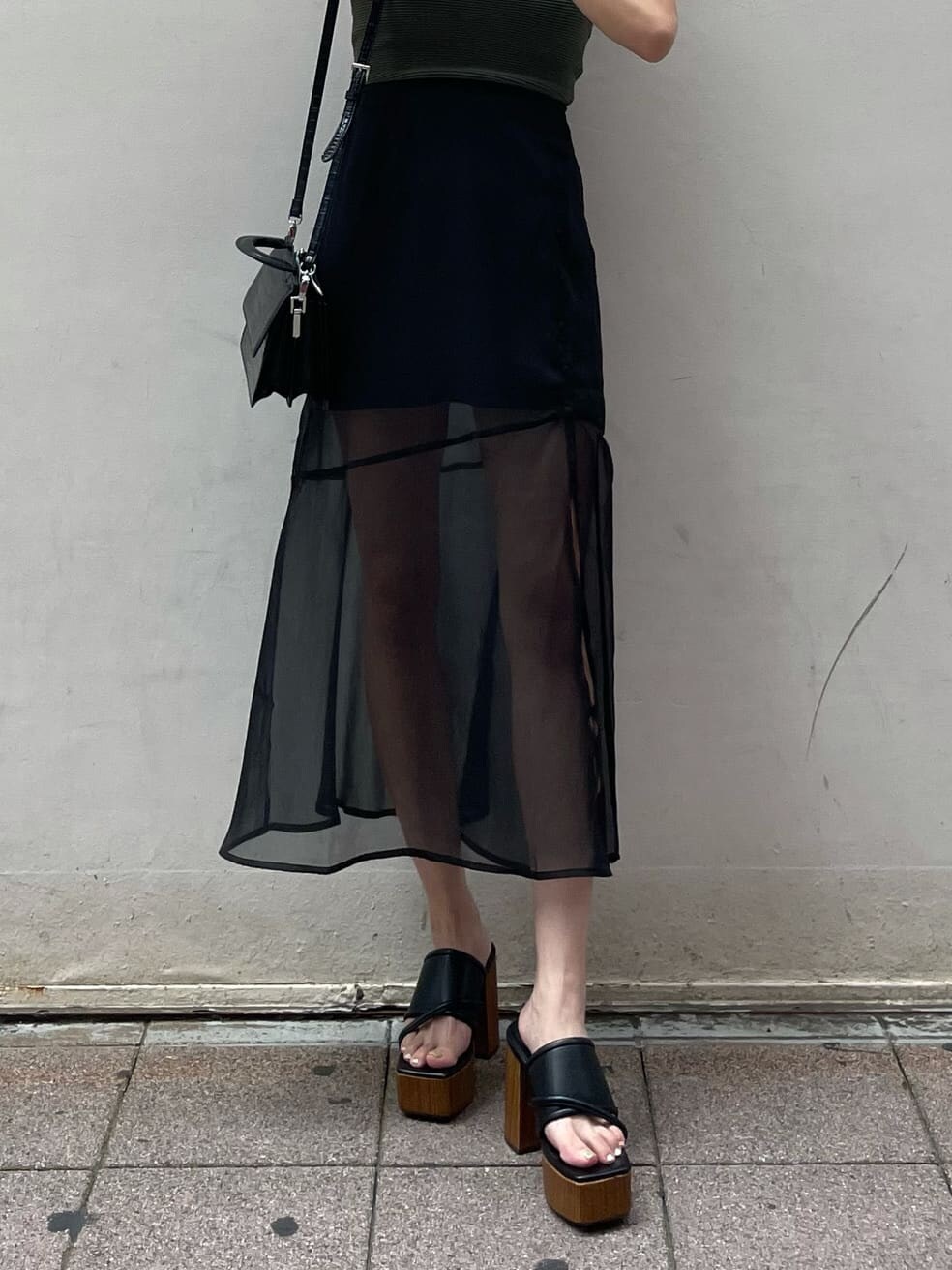 ブラック系のスカート、ブラック系のサンダル、ベージュ系のTシャツ/カットソーを着用したレディースの夏コーディネートの5枚目の写真