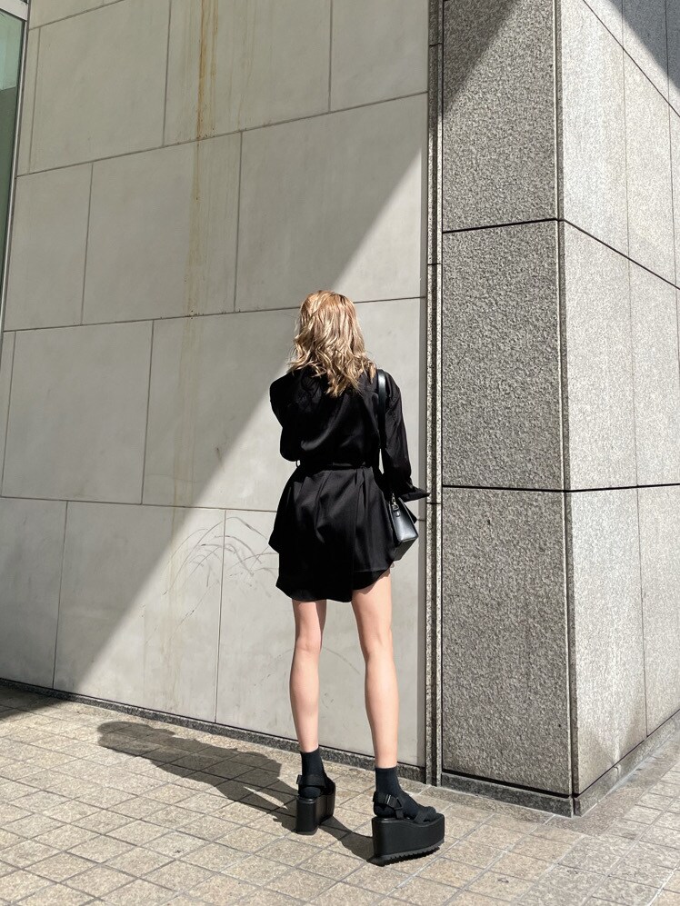 ブラウン系のスカート、ブラック系のショルダーバッグ、ブラック系のテーラードジャケットを着用したレディースの春コーディネートの4枚目の写真