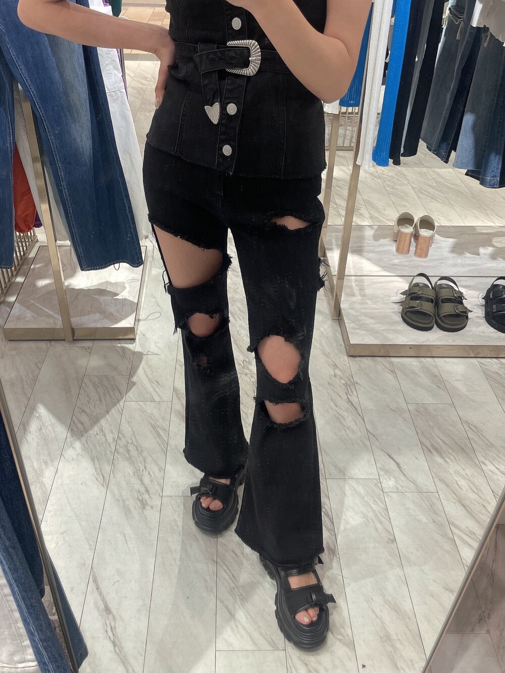 ブラック系のチューブトップ、ブラック系のデニムパンツ、ブラック系のサンダルを着用したレディースの春コーディネートの4枚目の写真