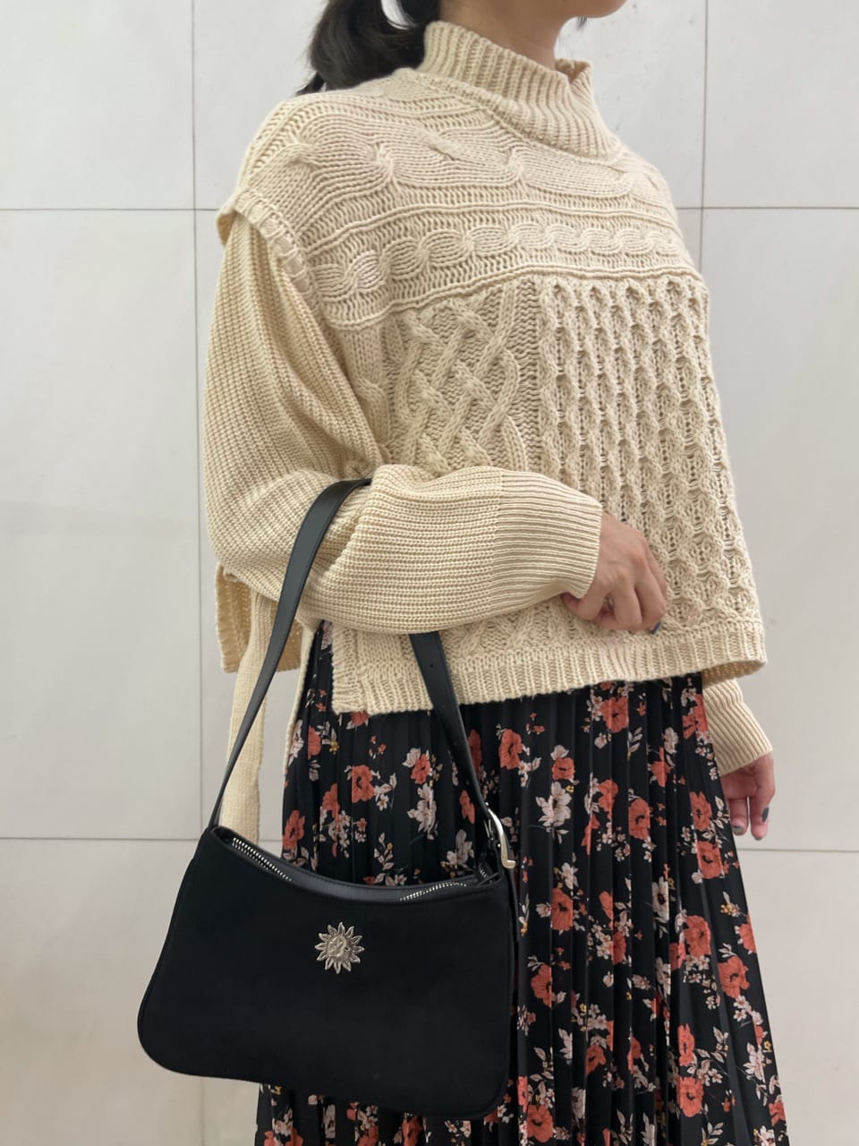 ブラック系のショルダーバッグ、ホワイト系のニット/セーター、ブラック系のスカートを着用したレディースの秋コーディネートの5枚目の写真