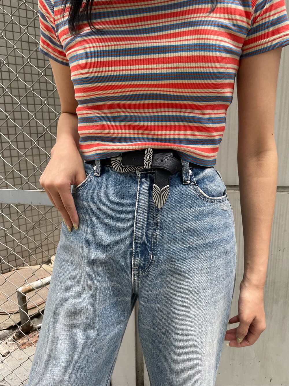 ブラック系のサンダル、ブルー系のデニムパンツ、オレンジ系のTシャツ/カットソーを着用したレディースの夏コーディネートの5枚目の写真