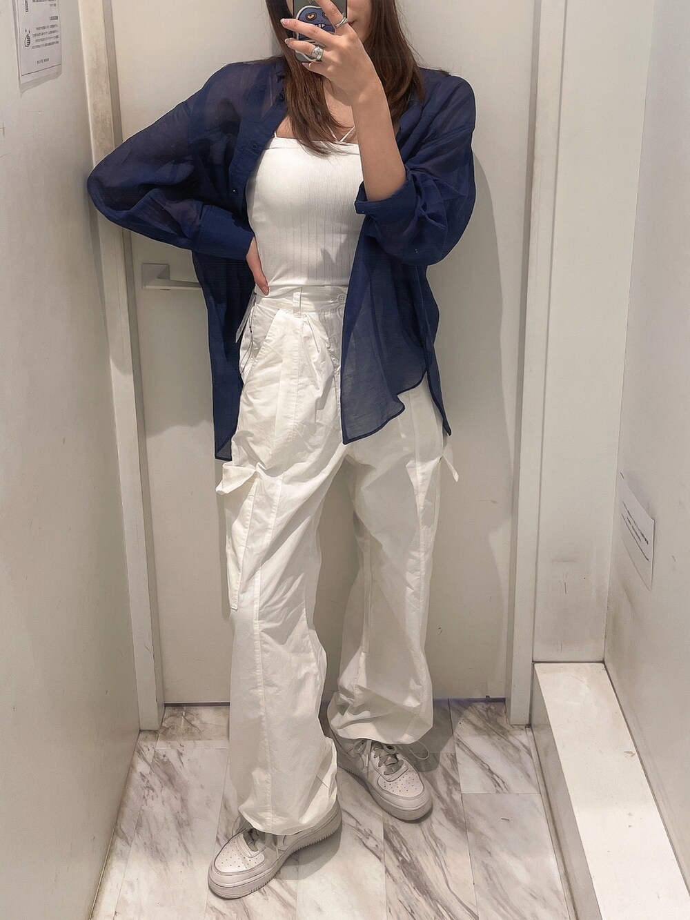 ブルー系のシャツ/ブラウス、ホワイト系のキャミソール、ホワイト系のカーゴパンツを着用したレディースの春コーディネートの3枚目の写真