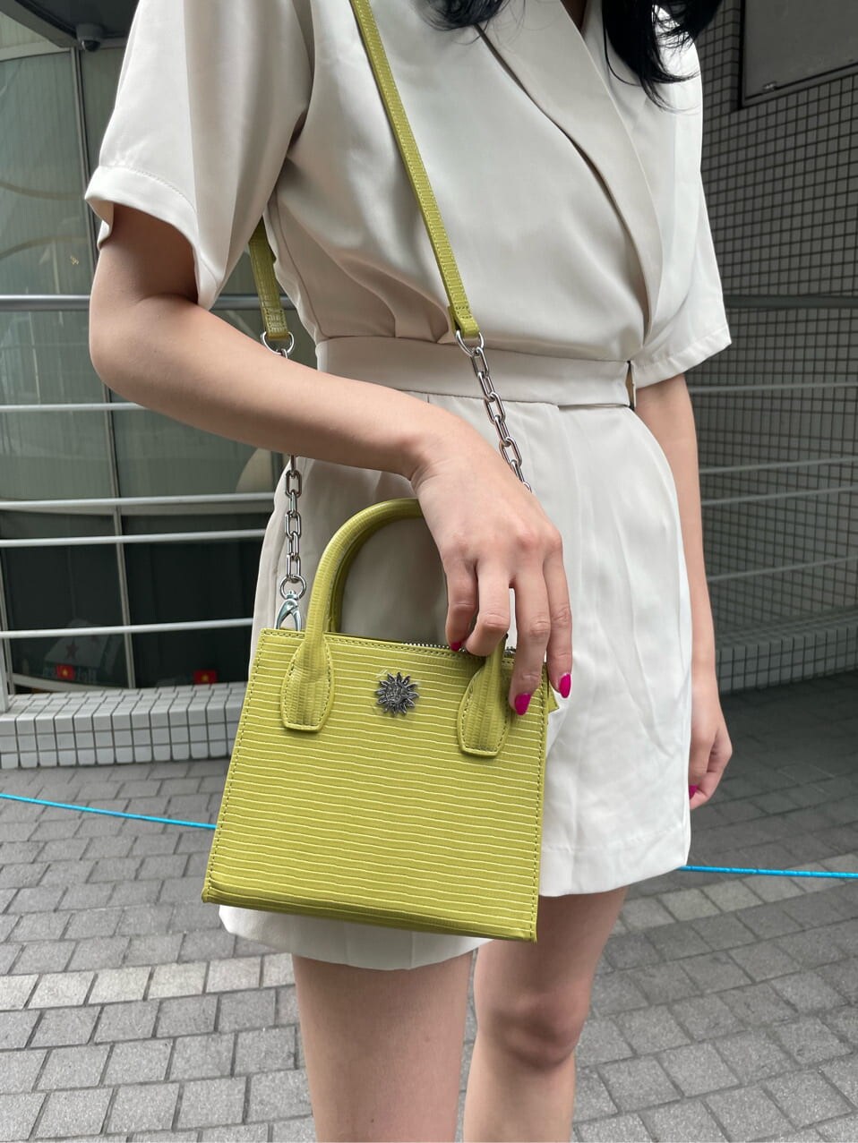 ホワイト系のつなぎ/オールインワン、ブラック系のブーツ、イエロー系のショルダーバッグを着用したレディースの春コーディネートの5枚目の写真