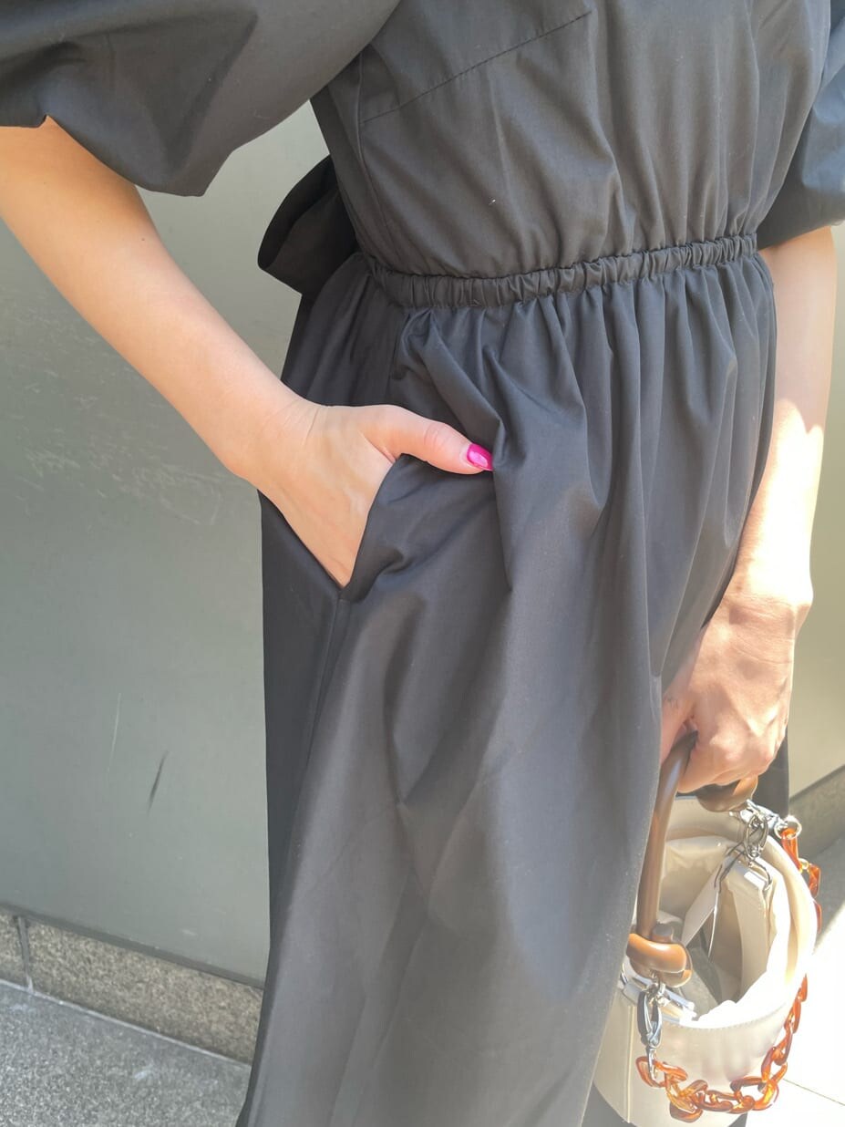 ブラック系のワンピース、ホワイト系のサンダル、ホワイト系のショルダーバッグを着用したレディースの春コーディネートの6枚目の写真