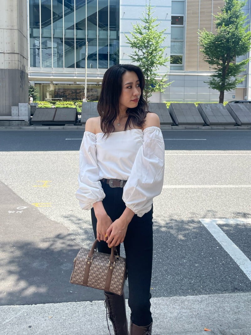 ブラウン系のブーツ、ブラウン系のボストンバッグ、ホワイト系のシャツ/ブラウスを着用したレディースの秋コーディネートの3枚目の写真